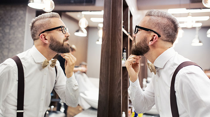 Man using a mirror to illustrate mirroring psychology in marketing.