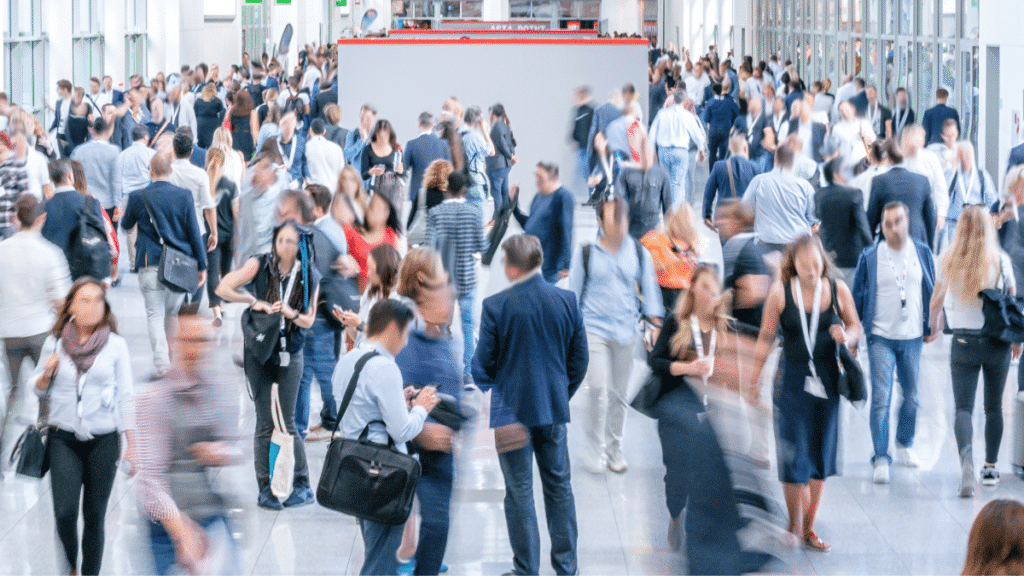 business professionals walking in trade show action shot for blog: "7 Reasons Why Trade Shows Are Still Essential For B2B Marketers"