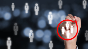 Hand circling group of people icons indicating finding or identifying a group
